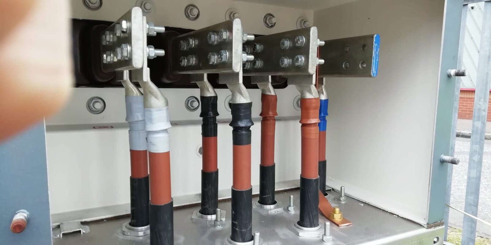 Heavy supply cables terminated onto busbars inside a commercial cabinet